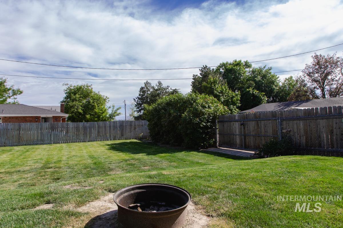 1404 Rochester Street Caldwell, ID 83605 - Photo 24 of 29 Expansive backyard featuring a lush lawn, mature perimeter trees, and a full privacy fence