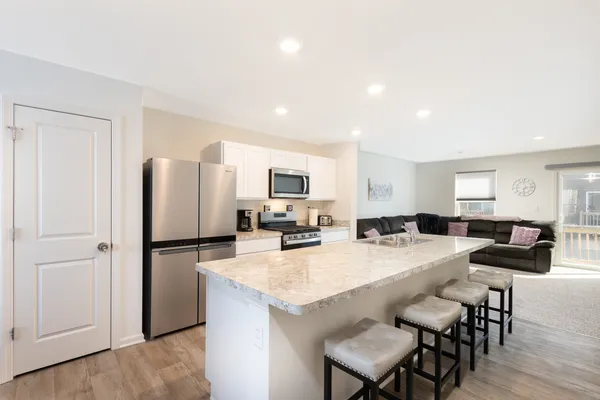 a kitchen with refrigerator and chairs