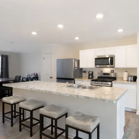 a kitchen with sink a microwave and cabinets