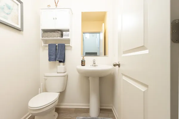 a bathroom with a toilet a sink and mirror