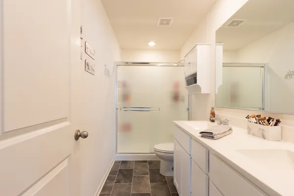 a bathroom with a sink a toilet and shower