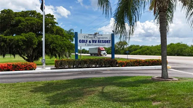 a sign board with a small yard and potted plants