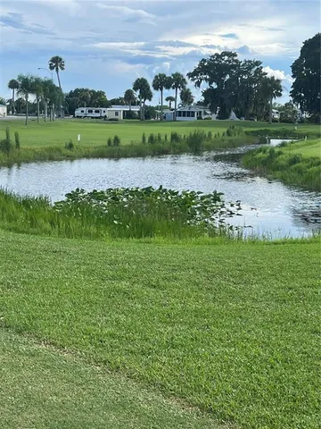 an aerial view of a golf course with a lake view