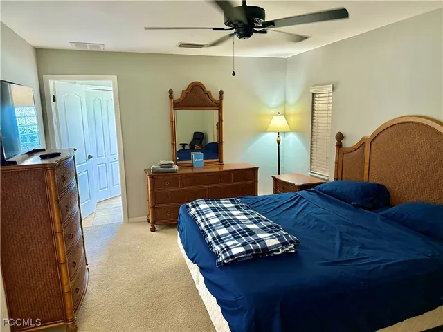 a bedroom with a bed and a mirror on dresser