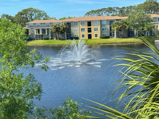 a view of a house with pool plants and large trees