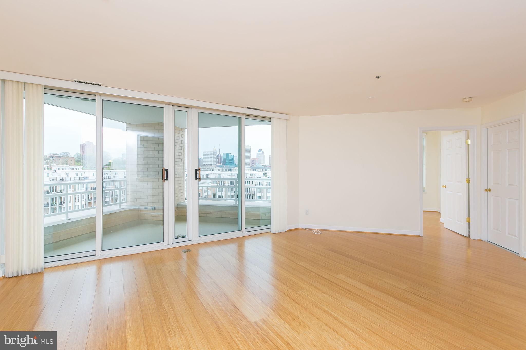 100 Harborview Drive, Unit 513 Baltimore, MD 21230 - Photo 7 of 58 a view of an empty room with wooden floor and a window