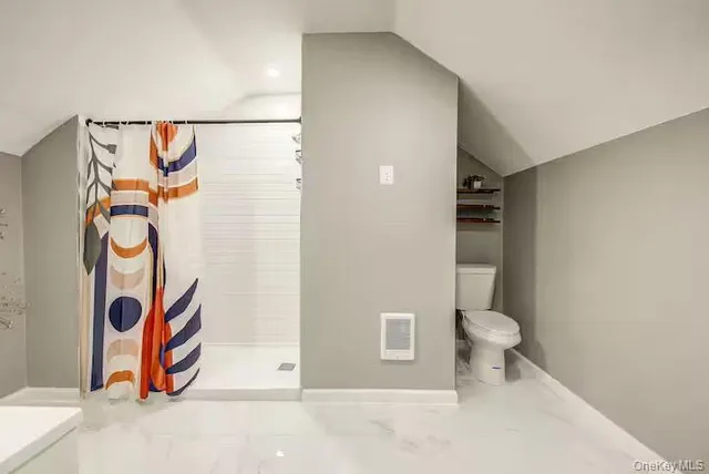 a bathroom with a toilet and a shower