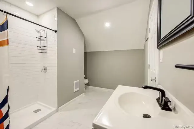 a bathroom with a sink a toilet and shower
