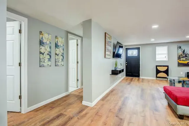 a view of a hallway with wooden floor and furniture