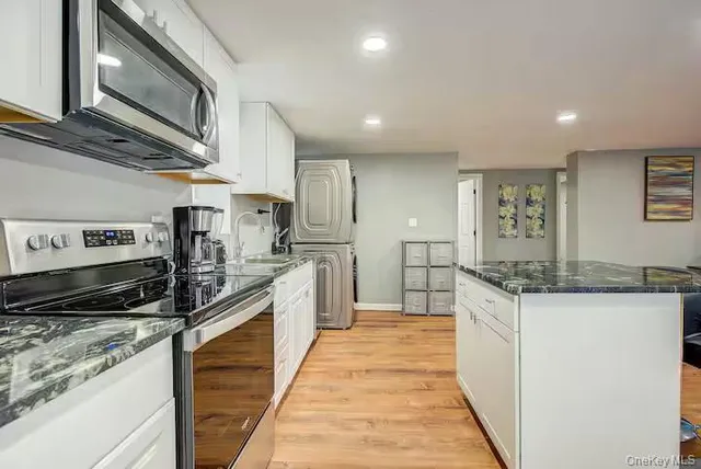 a kitchen with stainless steel appliances granite countertop a stove and a sink