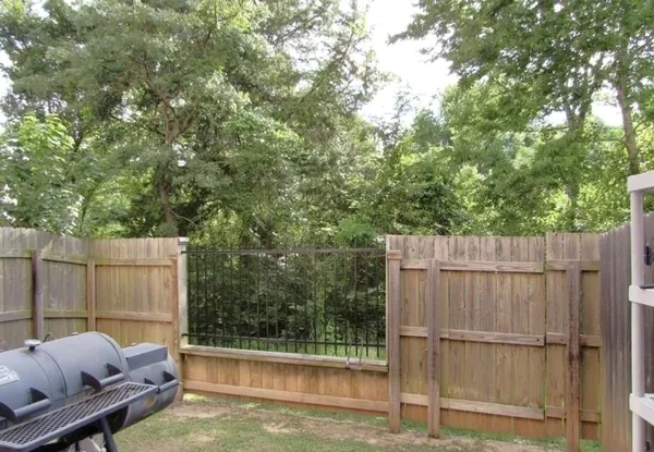 a view of a backyard with a small cabin and wooden fence