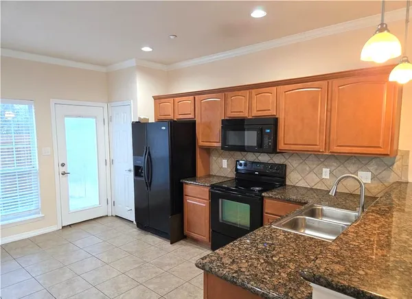 a kitchen with stainless steel appliances granite countertop a refrigerator stove and sink