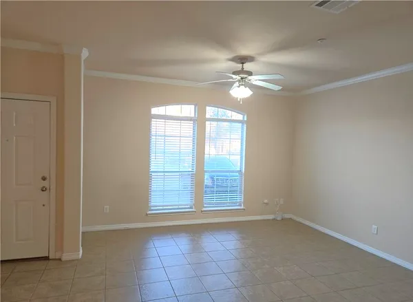 an empty room with windows and fan