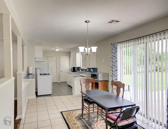 a kitchen with stainless steel appliances kitchen island granite countertop a refrigerator a stove a sink dishwasher with a dining table and chairs