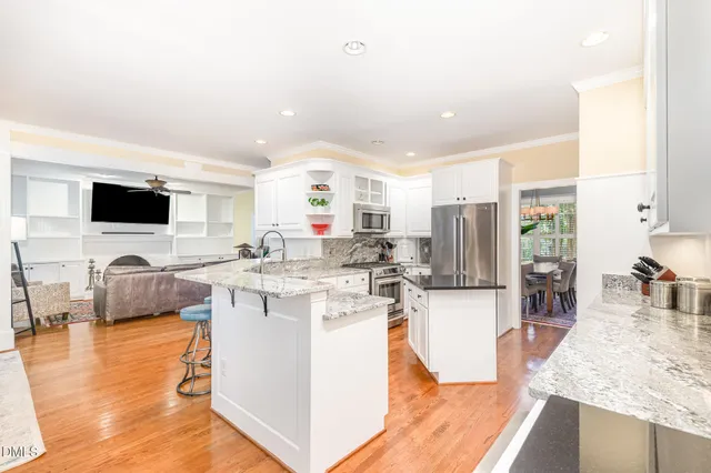 a kitchen with stainless steel appliances kitchen island granite countertop a stove and a sink