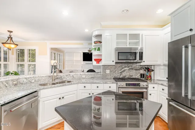 a kitchen with kitchen island granite countertop a stove sink and microwave