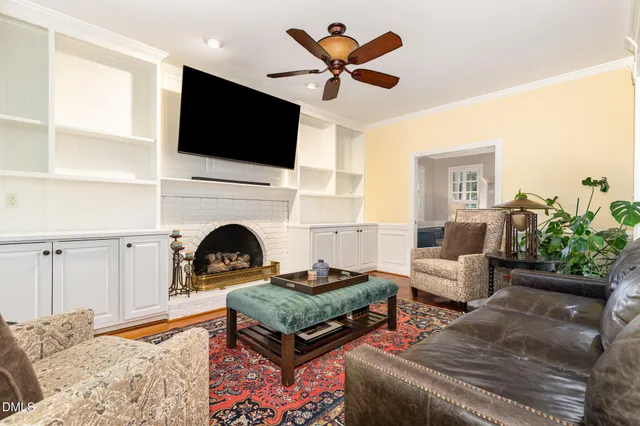a living room with furniture a flat screen tv and a fireplace