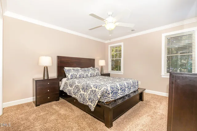 a bed sitting in a bedroom next to a window and a chandelier