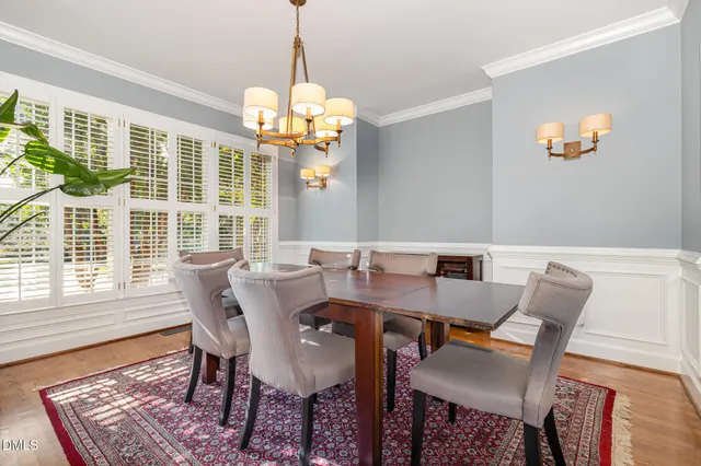 a view of a dining room with furniture a chandelier and wooden floor