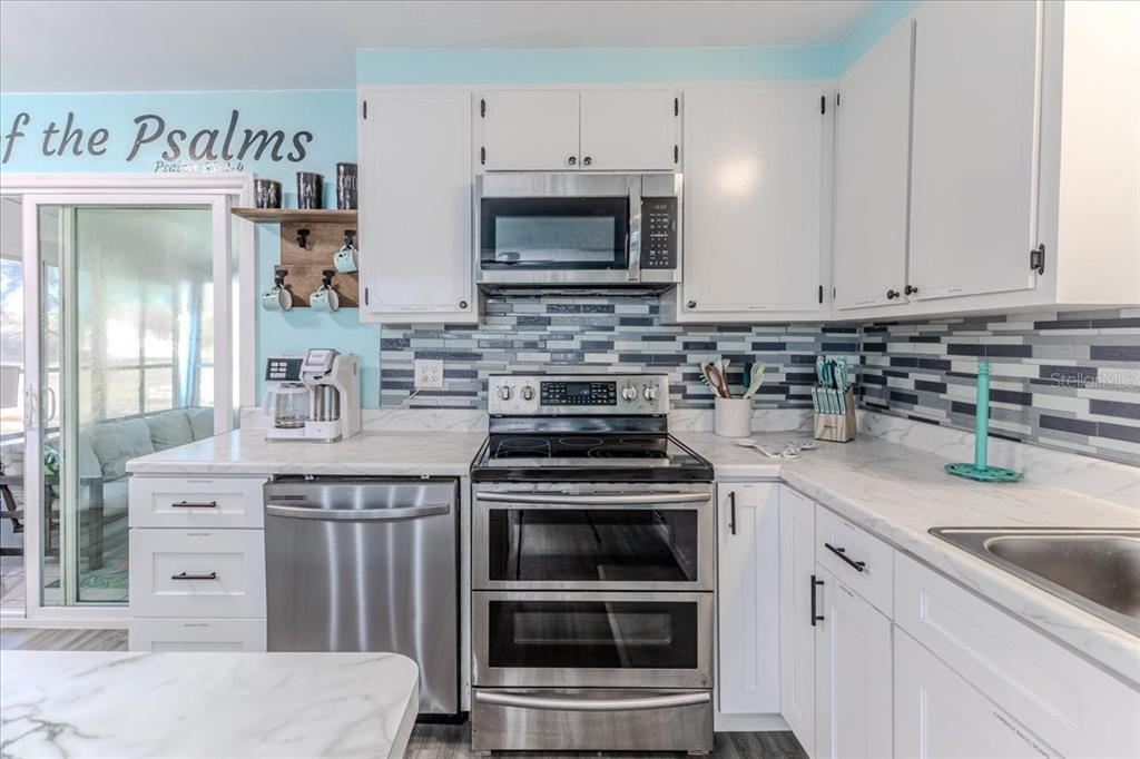 5261 Circle Drive Weeki Wachee, FL 34607 - Photo 24 of 49 a kitchen with stainless steel appliances granite countertop a stove and a microwave
