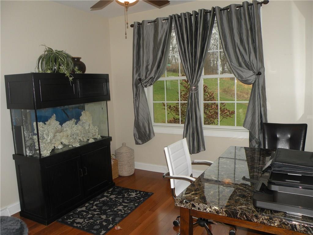 1145 Mohawk Road McDonald, PA 15057 - Photo 10 of 24 1145 Mohawk Road 1st Floor Den - Neutral wall tone, polished hardwood flooring, ceiling fan with light, large windows