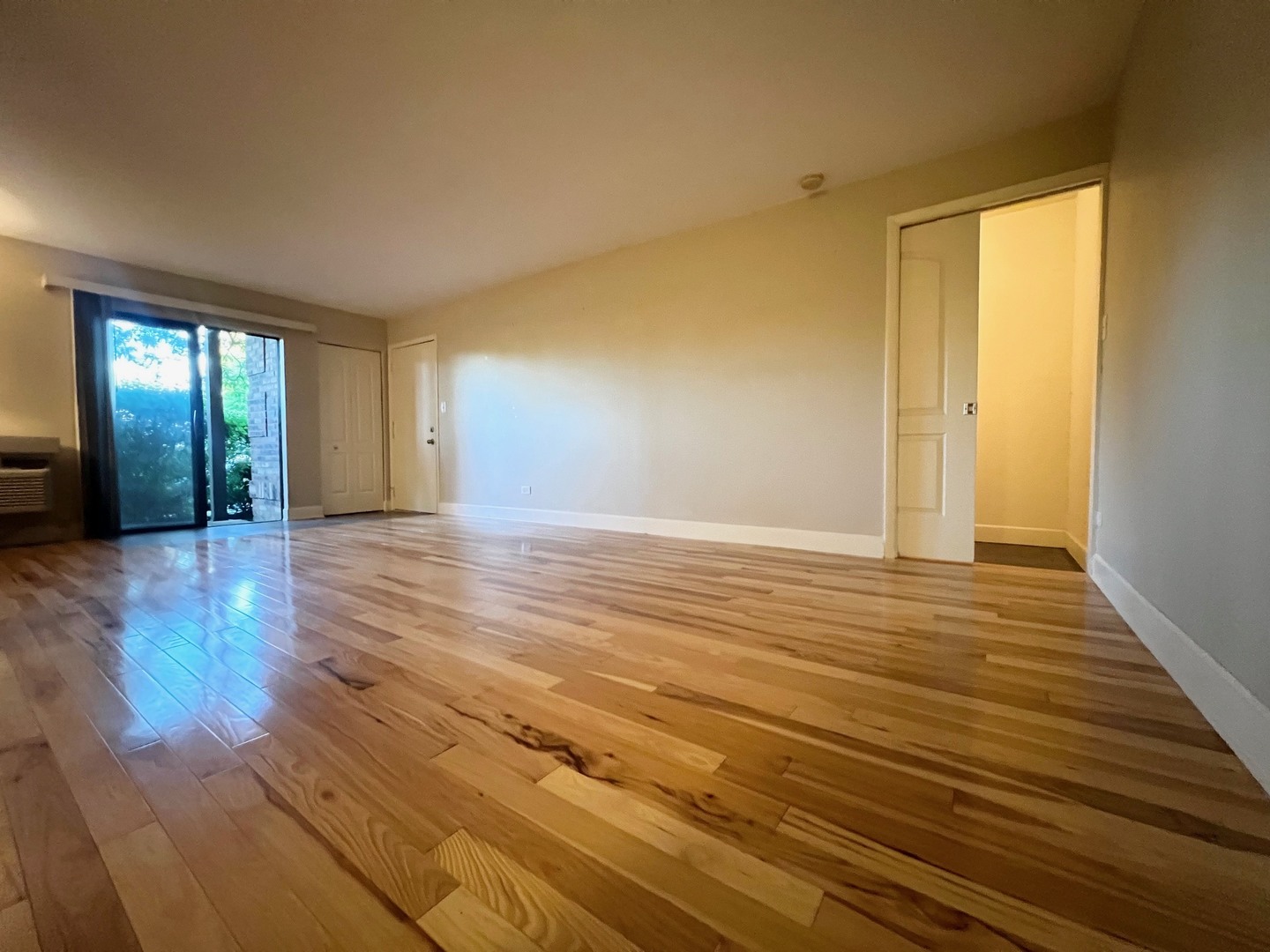 2219 Nichols Road, Unit 17A Arlington Heights, IL 60004 - Photo 10 of 19 a view of an empty room with wooden floor and a window