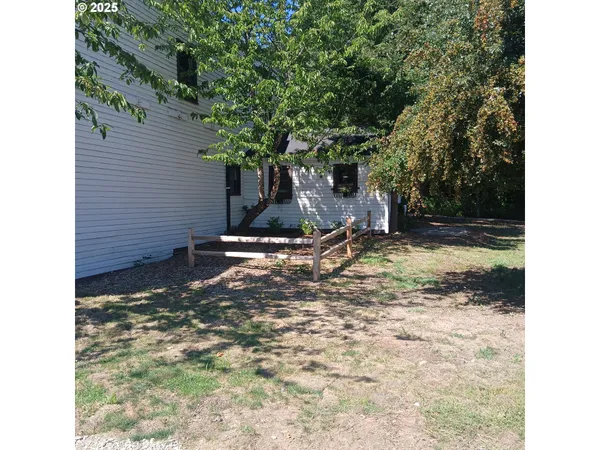 a view of brick house with backyard and chairs