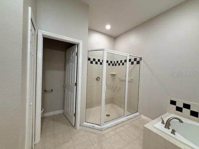 a bathroom with a granite countertop tub shower and mirror