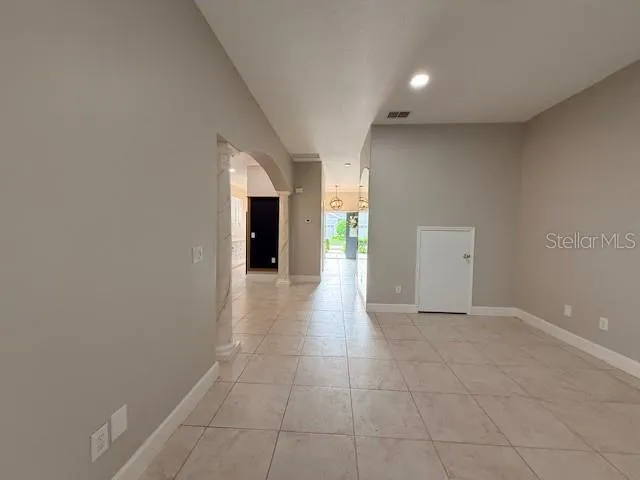 a view of a hallway with an empty room and a window