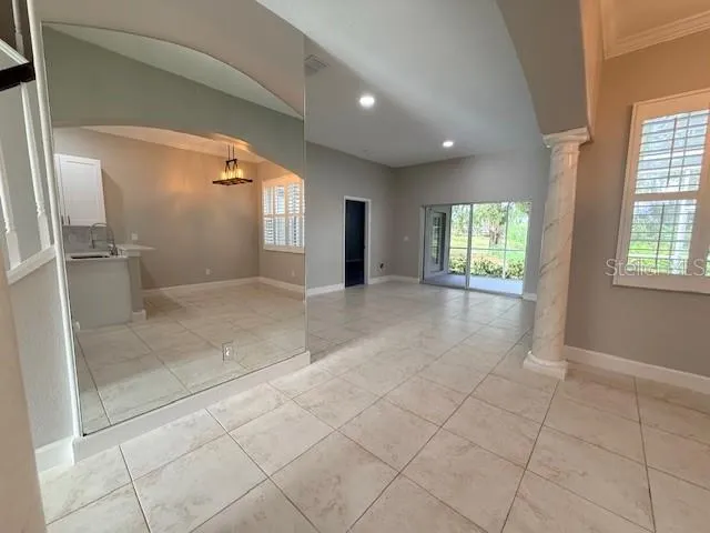 a view of a hallway with windows and chandelier
