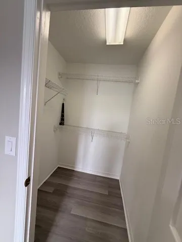 a view of walk in closet with wooden floor