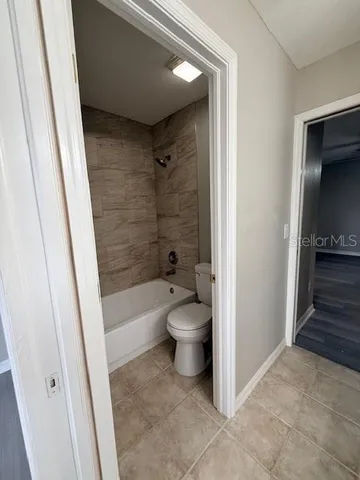 a bathroom with a granite countertop bathtub shower and toilet