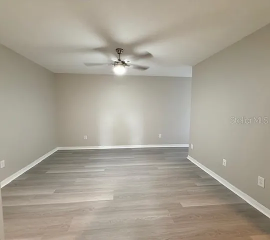 a view of an empty room with wooden floor