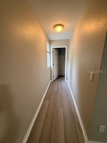 a view of a hallway with wooden floor