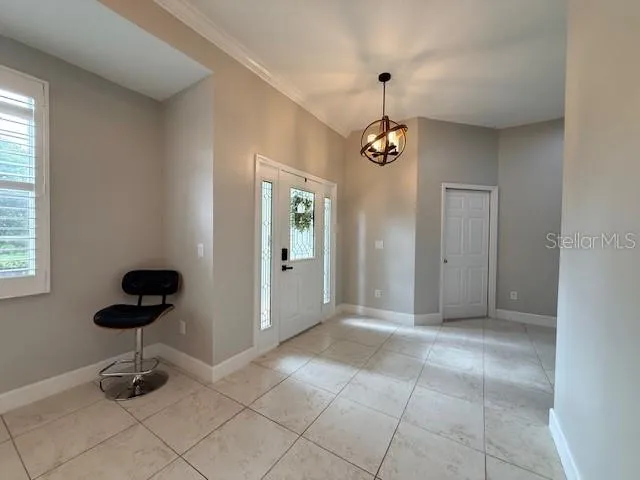 a view of a livingroom with a chandelier fan and windows