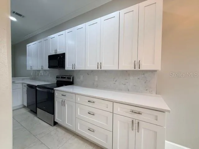 a kitchen with white cabinets and a stove