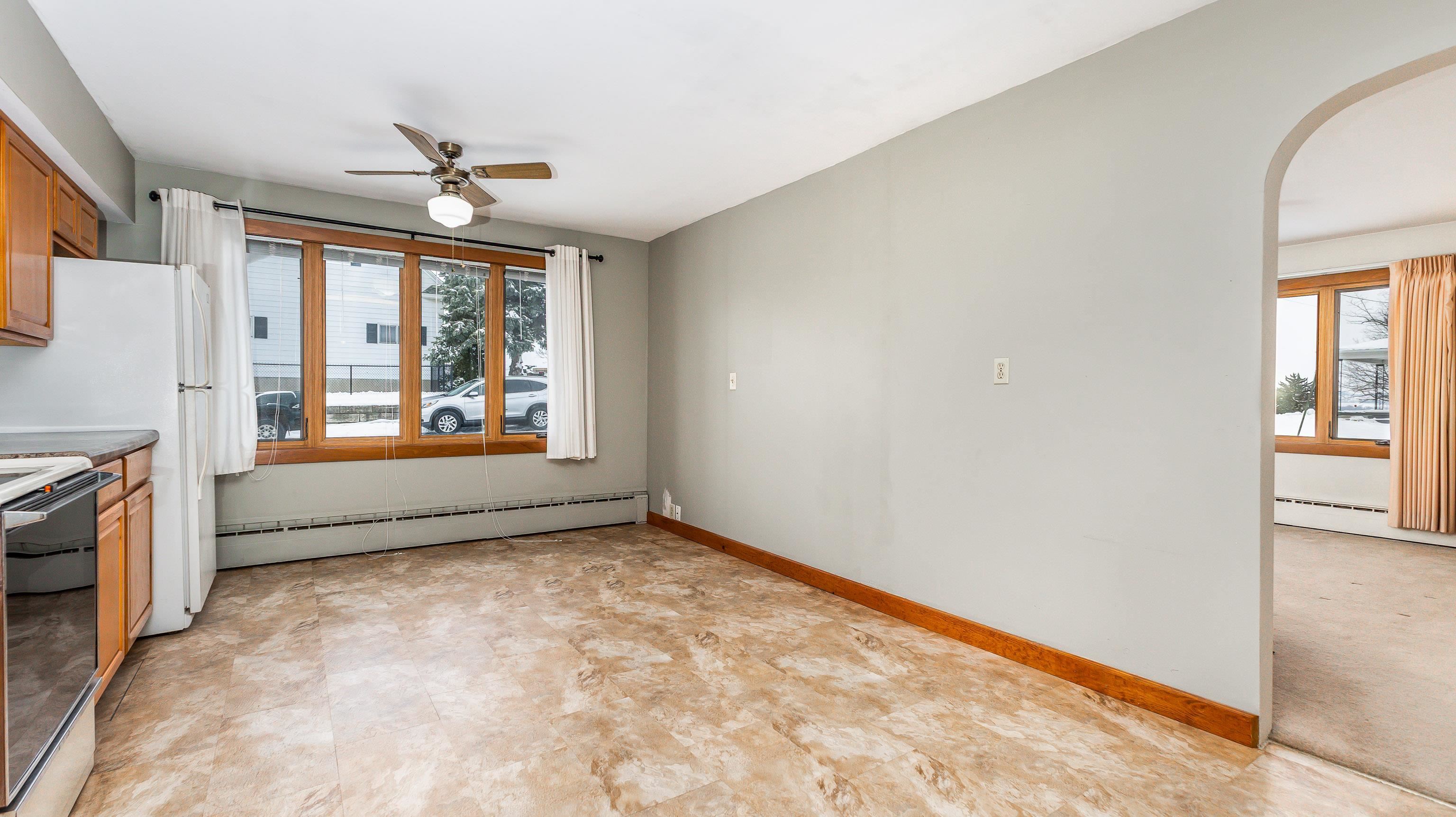 319 East Catlin Street Elizabeth, IL 61028 - Photo 6 of 26 an empty room with windows and chandelier fan