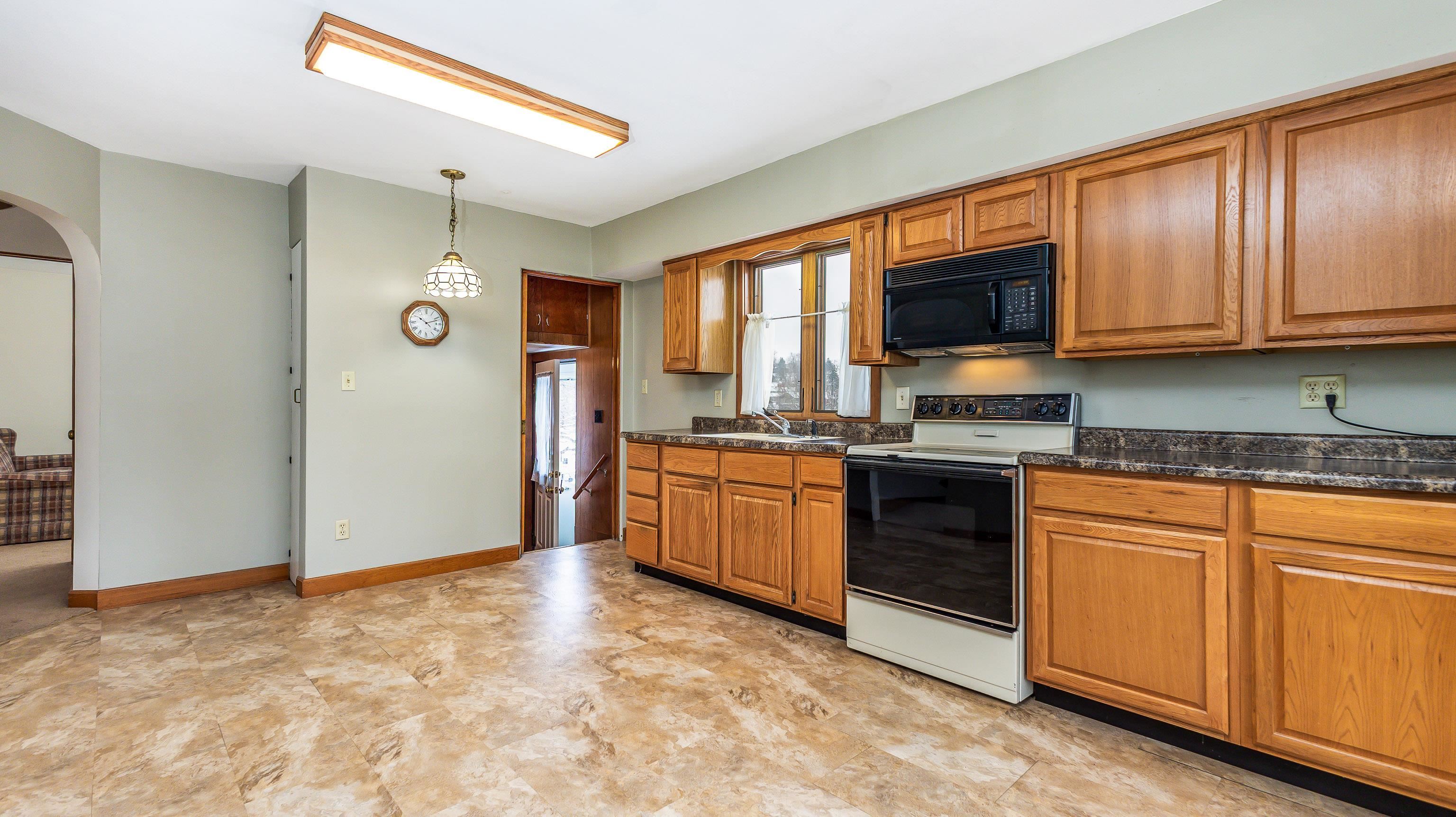 319 East Catlin Street Elizabeth, IL 61028 - Photo 8 of 26 a kitchen with granite countertop a stove top oven sink and cabinets