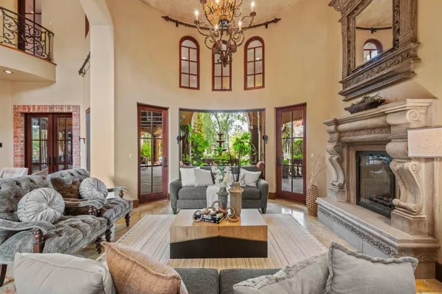 a dining room with wooden floor a chandelier a wooden table and chairs