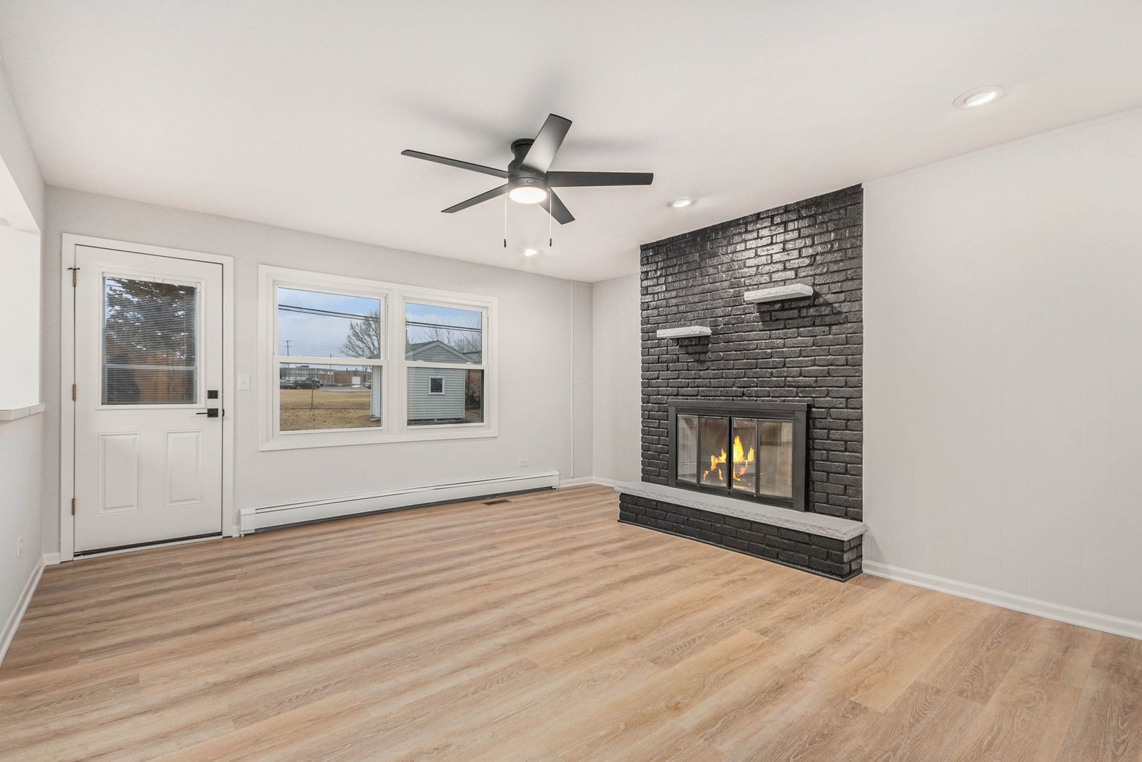 323 Chicago Road Oswego, IL 60543 - Photo 6 of 27 a view of an empty room with a window and fireplace