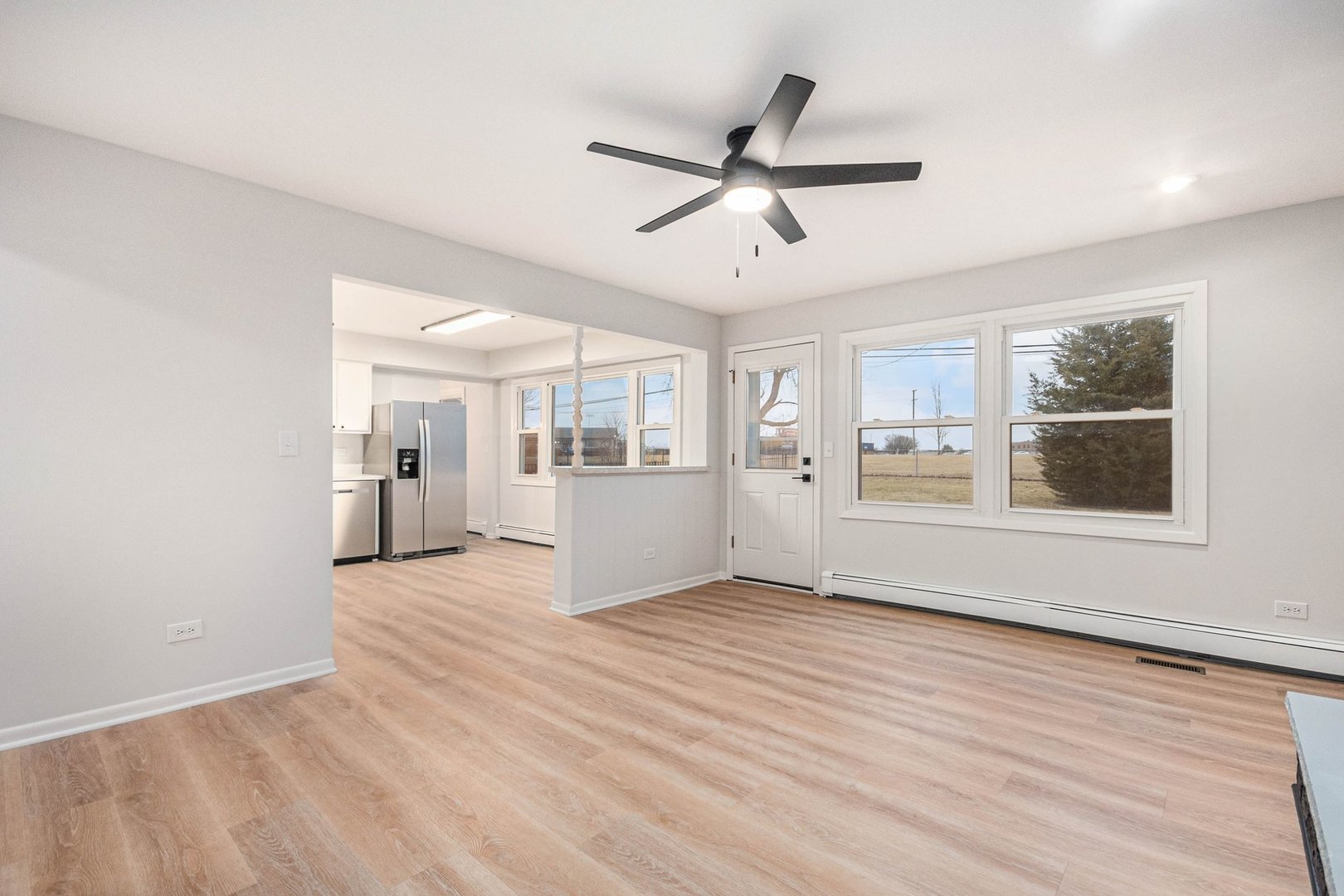 323 Chicago Road Oswego, IL 60543 - Photo 7 of 27 a view of an empty room with a window and wooden floor