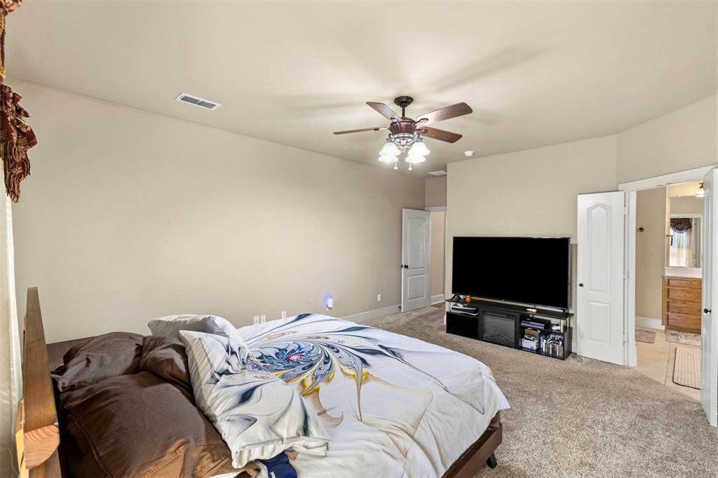 105 Country Ridge Court Red Oak, TX 75154 - Photo 21 of 40 a bedroom with a bed and a flat screen tv