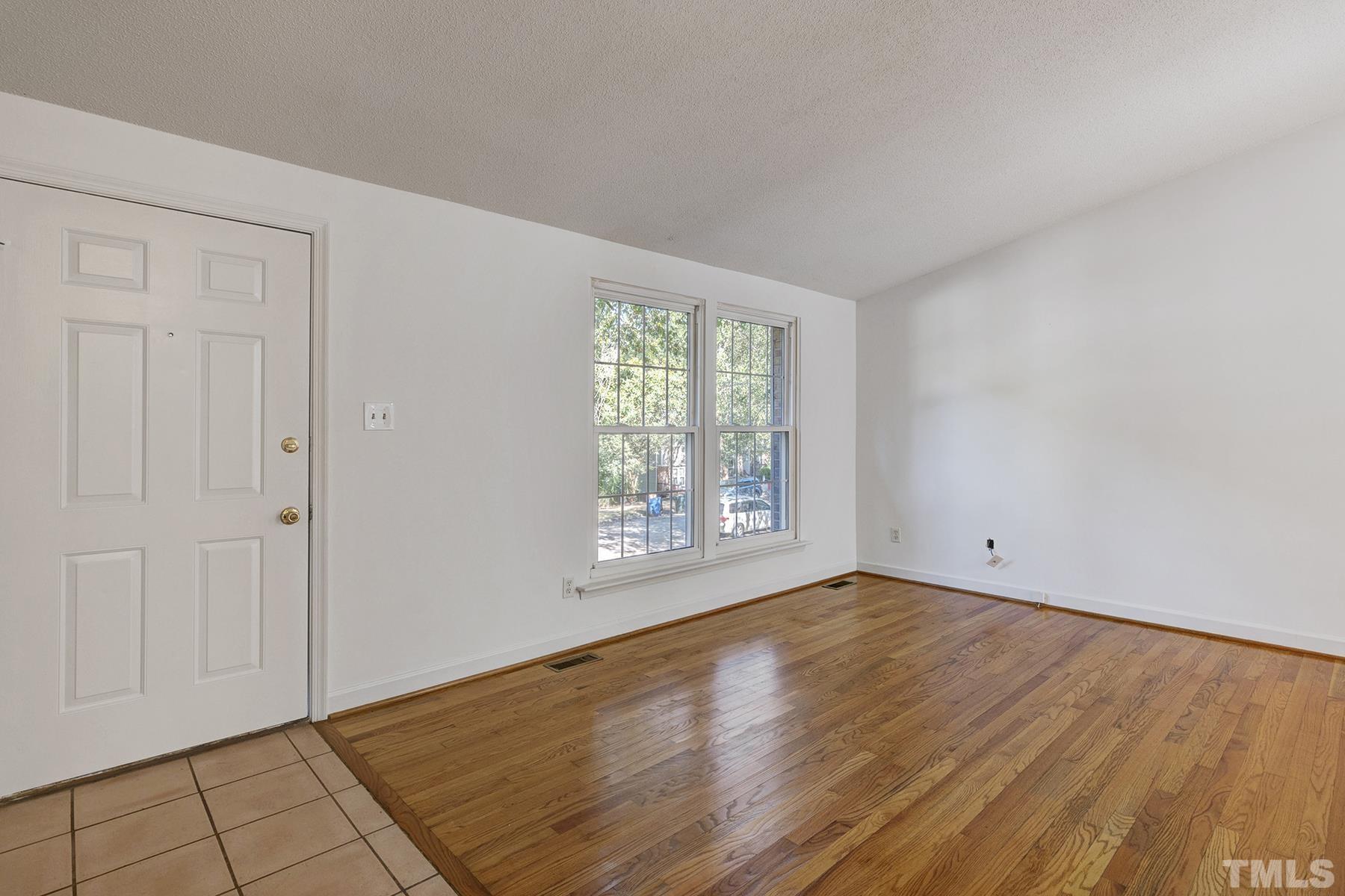 7317 Shellburne Drive Raleigh, NC 27612 - Photo 18 of 28 a view of an empty room with wooden floor and a window