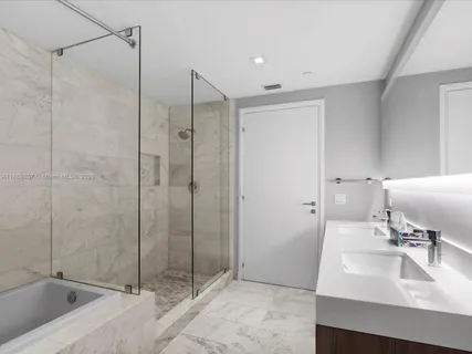 a bathroom with a shower sink and mirror