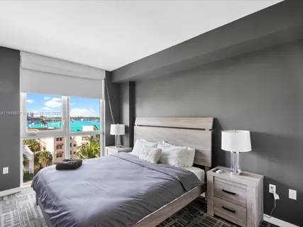 a bedroom with a bed and large windows