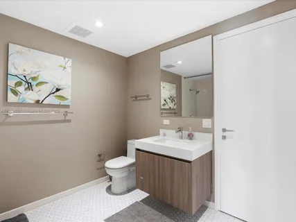 a bathroom with a sink a toilet and a mirror