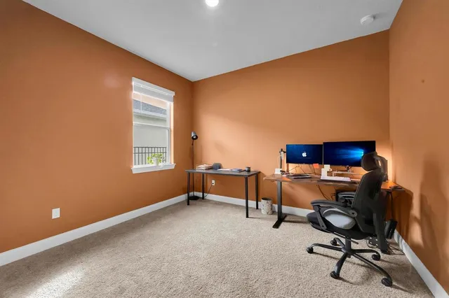 a living room with furniture a wooden floor and a view of kitchen