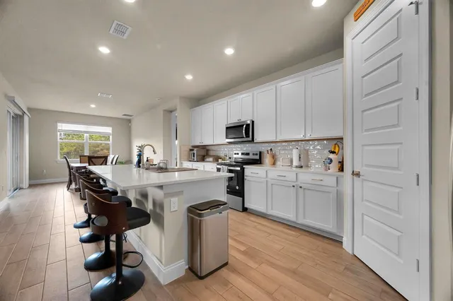 a kitchen with granite countertop a sink and white cabinets