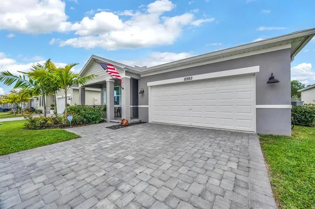 a view of a backyard with plants and chairs