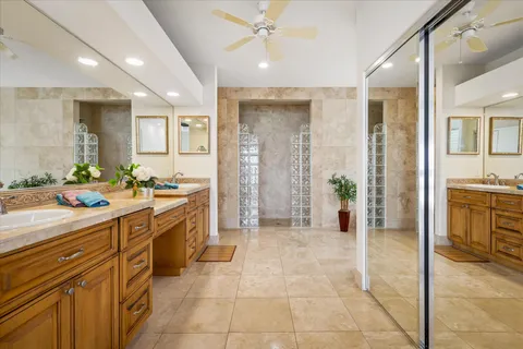 a bathroom with a granite countertop sink mirror vanity and toilet